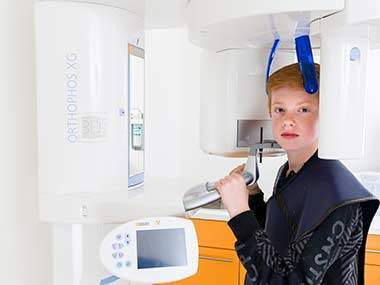Kind sitzt in ORTHOPHOS XG 3 Röntgengerät